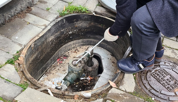 용인시 상수도사업소 관계자가 관내 한 수용가의 수도 계량기를 점검하고 있는 모습(용인시청 제공)