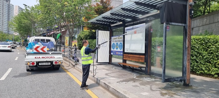 수지구 관계자가 고압세척기로 승장장을 청소하고 있는 모습 (사진 - 용인시 제공)