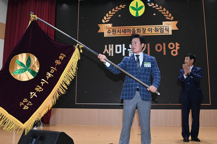 홍순주 신임회장이 수원시새마을회 깃발을 흔들고 있다.