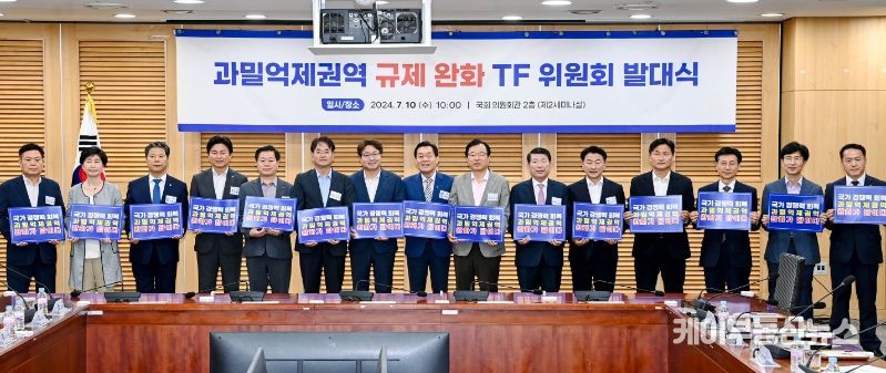 과밀억제권역 규제 완화 TF위원회 대표위원장으로 선출된 이재준 수원시장(오른쪽 8번째부터), 염태영 의원, 이동환 고양시장 등이 TF 위원회 발대식 후 ‘국가경쟁력 회복 과밀억제권역 완화가 답이다’라는 문구가 적힌 손팻말을 들고 기념촬영을 하고 있다.