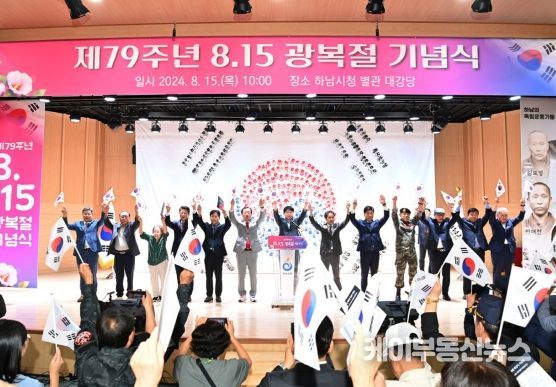 15일 열린 제79주년 광복절 기념식에서 참가자들이 태극기를 들고 만세삼창을 하고 있다.