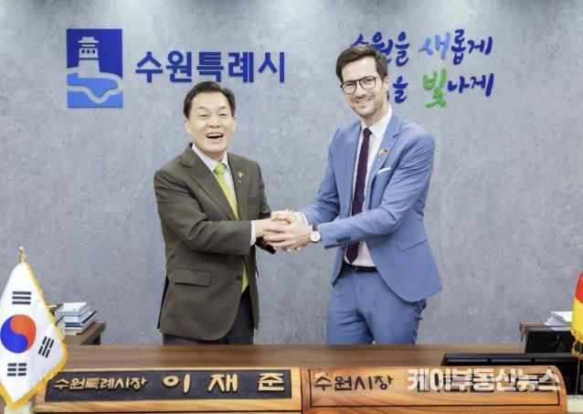이재준 수원시장이 마르틴 호른 프라이부르크시장에게 명예 수원시장 명패를 전달한 후 활짝 웃고 있다.