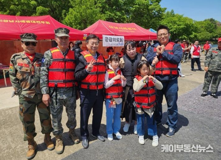 신상진 성남시장이 제103회 어린이날을 맞아 분당구 율동공원 호수에서 개최된 해병대 고무보트 승선 체험 행사에 참석해 현장을 찾은 시민들과 기념촬영을 하고 있다