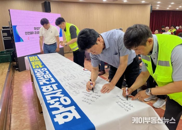 화성특례시 관내 공사현장 관계자 및 안전관리자들이 30일 무재해 결의대회에서 무재해 결의문 현수막에 안전기원 문구를 적고 있다.