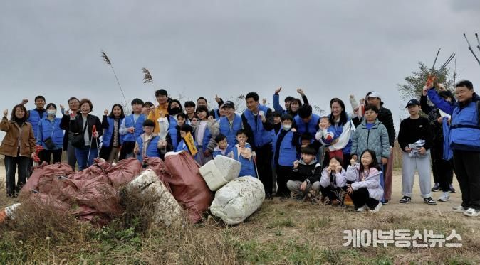 8일 화성시 가족봉사단과 함께하는 자원순환실천 연안정비활동 참가자들이 쓰레기 줍기 활동을 마치고 기념 촬영하고 있다